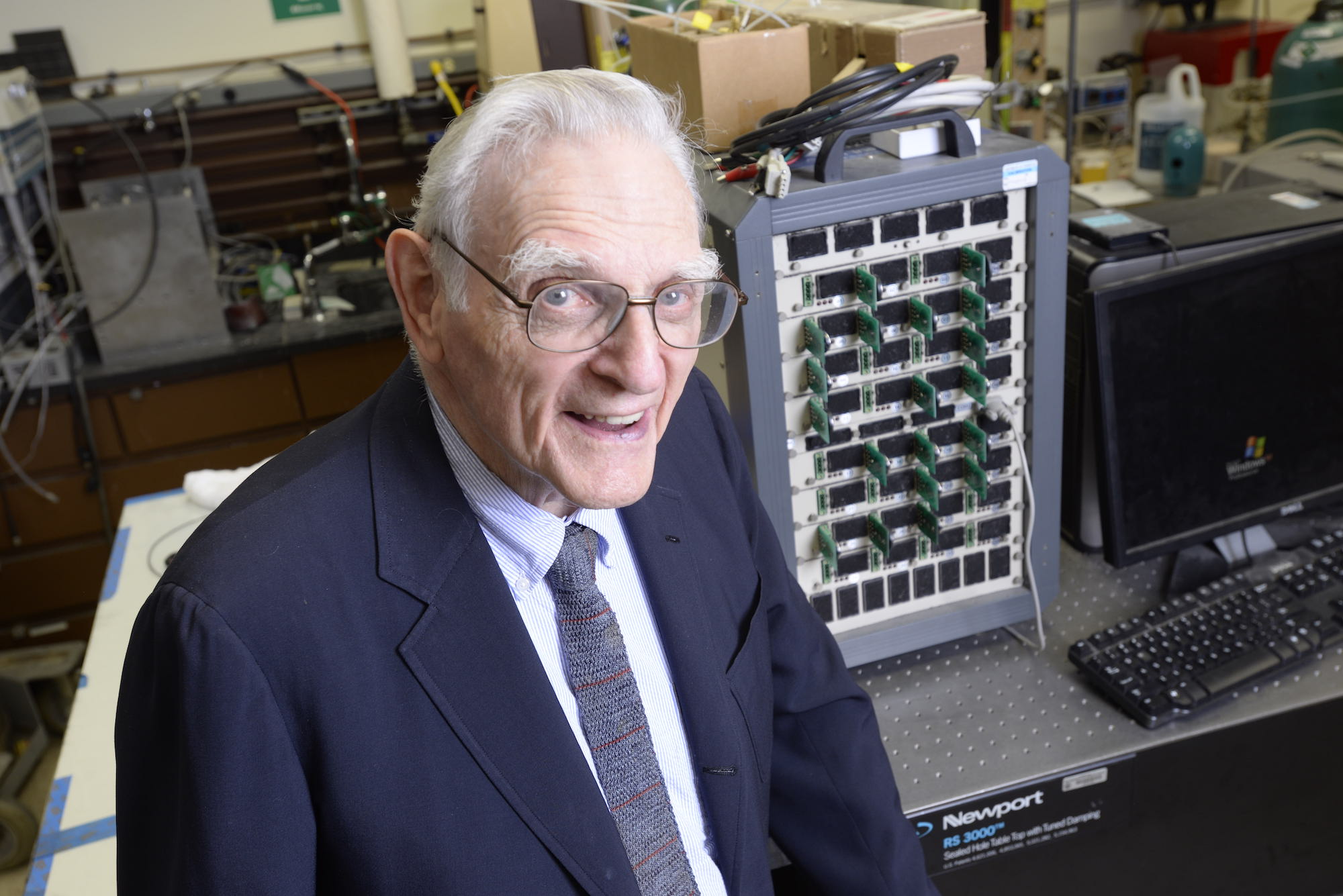 John Goodenough in the lab standing in front of some of his equipment