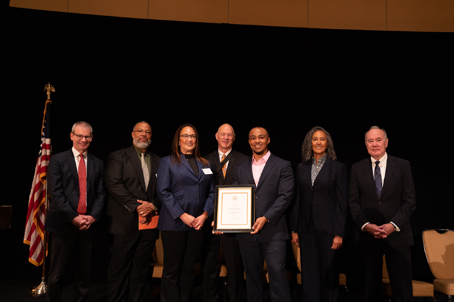 TX engineering alumnus Ervin Perry holding award with his family and UT Austin leadership