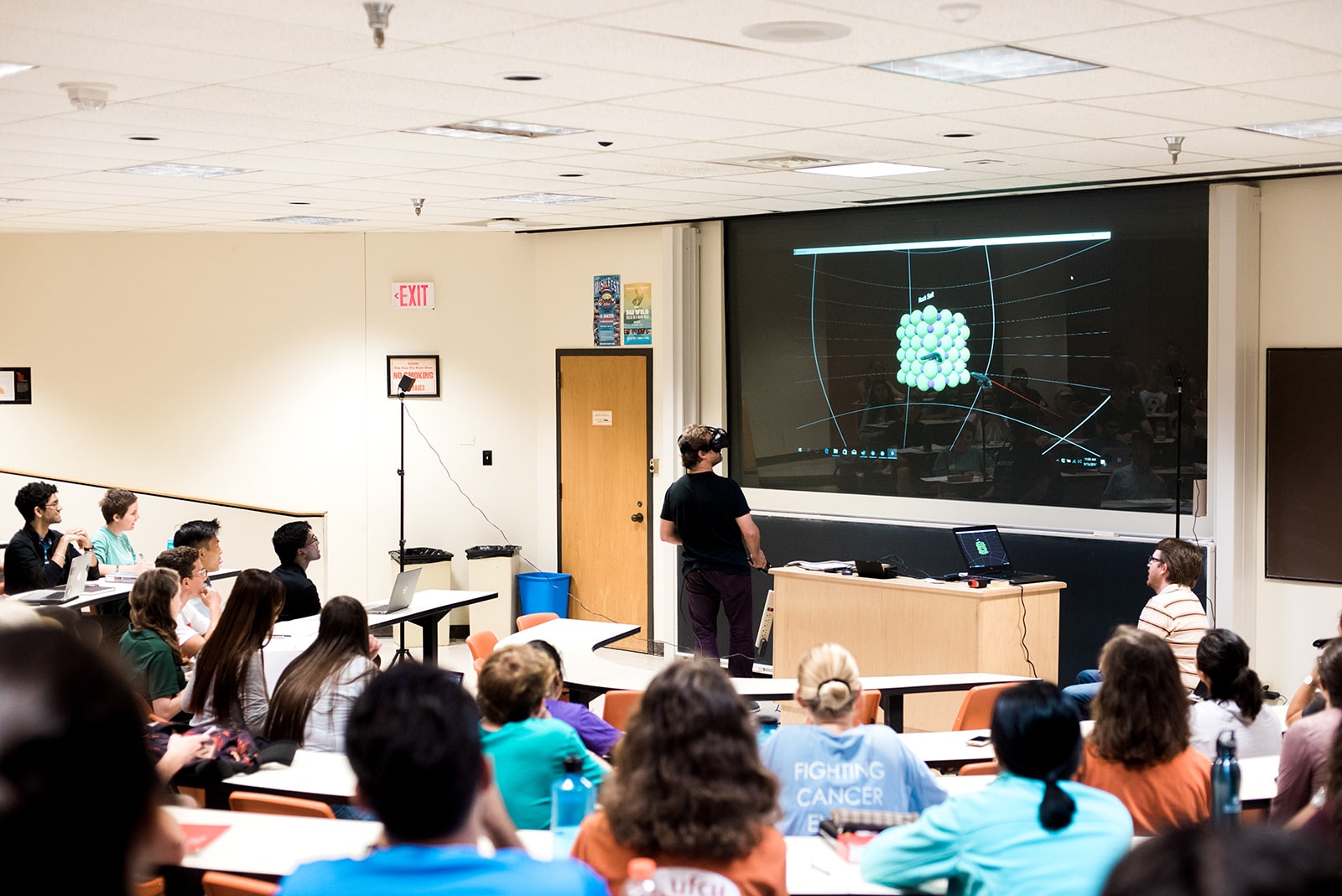 Professor Brian Korgel addresses a lecture hall full of Texas Engineering students while wearing a virtual reality headset.