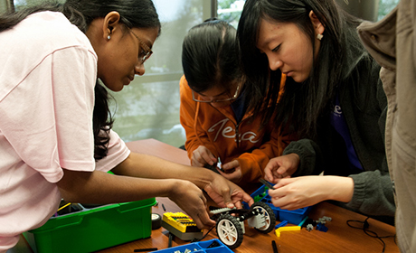 three female Tx engineering students working on a robotic car