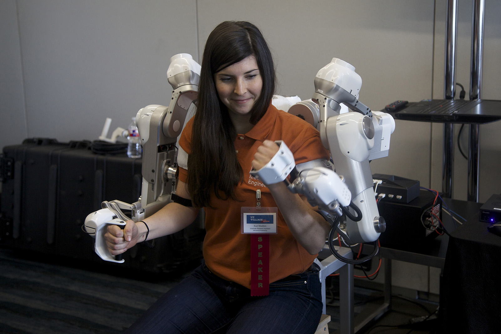 student wearing a UT Austin t-shirt operating robotic arms